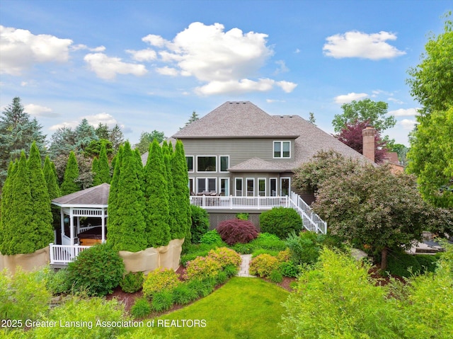 6378 E Island Lake Dr, East Lansing, MI 48823 - rear view of house with a wooden deck, a shingled roof, and a chimney