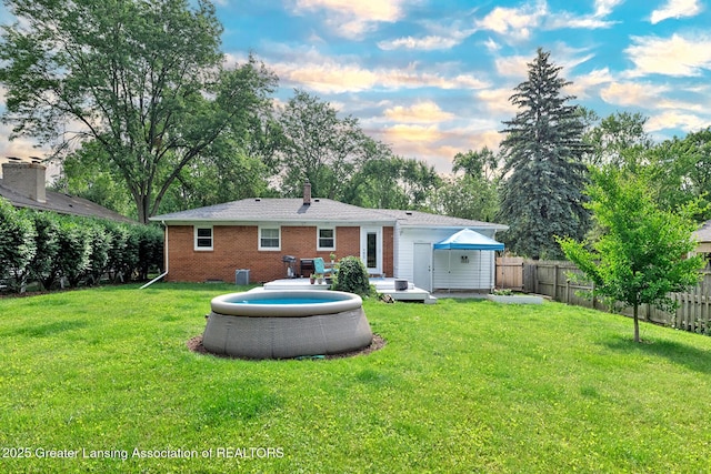 619 Wayland Ave, East Lansing, MI 48823 - rear view of house with a fenced backyard, brick siding, and a chimney