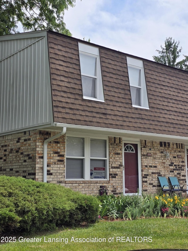 1755 Maisonette Dr, Lansing, MI 48911 - view of front of home featuring roof with shingles, brick siding, and mansard roof