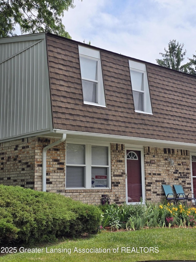 1755 Maisonette Dr, Lansing, MI 48911 - view of front of home featuring roof with shingles, mansard roof, and brick siding