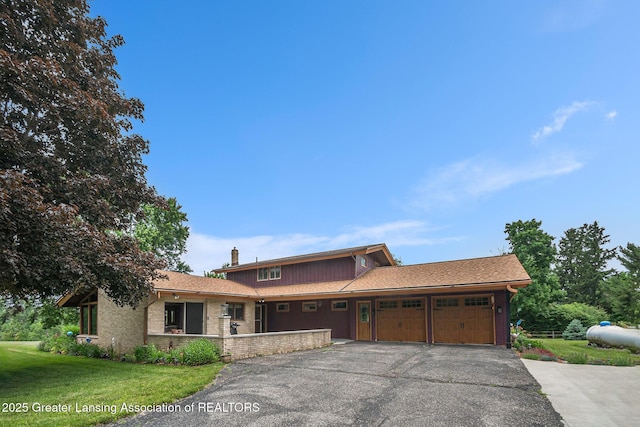 203 Branson Bay Dr, Mason, MI 48854 - view of front facade with a garage, asphalt driveway, a front yard, and a chimney