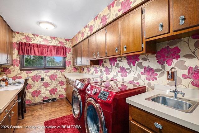 203 Branson Bay Dr, Mason, MI 48854 - washroom featuring wallpapered walls, independent washer and dryer, cabinet space, and light wood-style floors