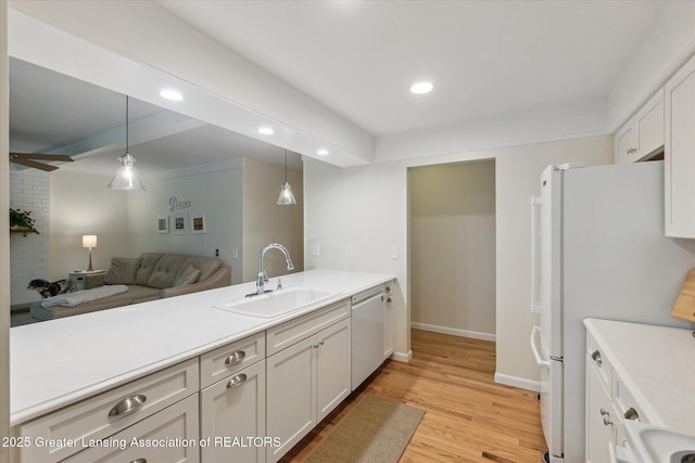 2130 Belding Ct, Okemos, MI 48864 - kitchen with dishwashing machine, decorative light fixtures, freestanding refrigerator, light wood-style flooring, and light countertops