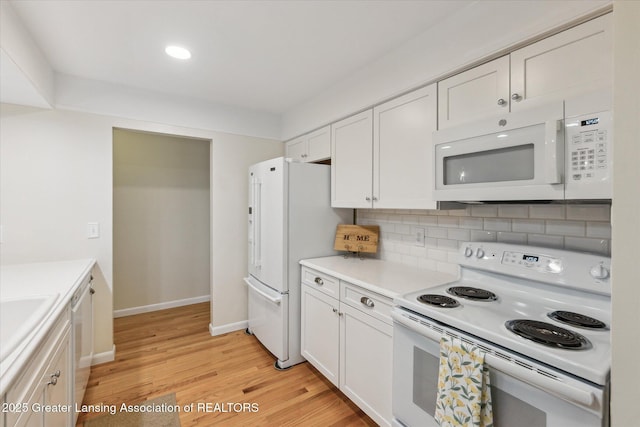 2130 Belding Ct, Okemos, MI 48864 - kitchen with white appliances, white cabinetry, light wood finished floors, backsplash, and light countertops