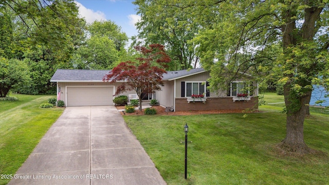 2130 Belding Ct, Okemos, MI 48864 - view of front of home with an attached garage, concrete driveway, and a front lawn