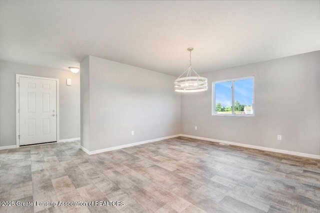 2905 Moccasin Dr, Dewitt, MI 48820 - empty room with light wood finished floors and a chandelier