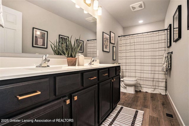 2905 Moccasin Dr, Dewitt, MI 48820 - bathroom with double vanity, wood finished floors, and a shower with shower curtain