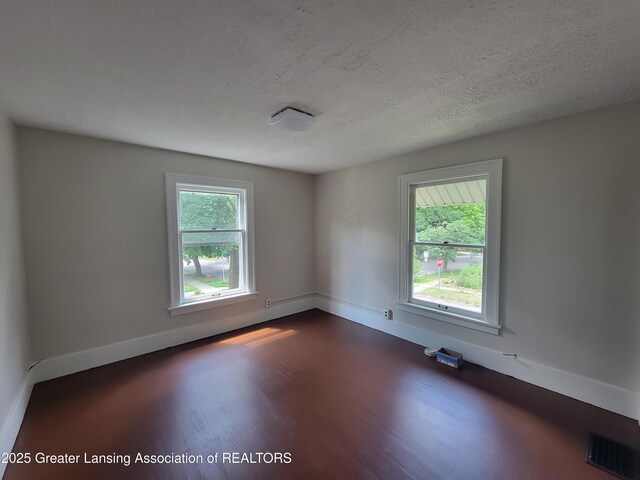 1201 Climax St, Lansing, MI 48912 - spare room featuring dark wood-type flooring and a textured ceiling
