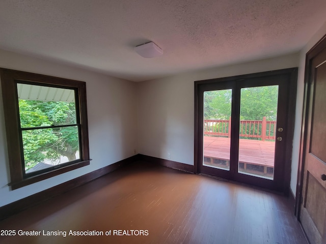 1201 Climax St, Lansing, MI 48912 - unfurnished room featuring plenty of natural light, dark wood-type flooring, and a textured ceiling