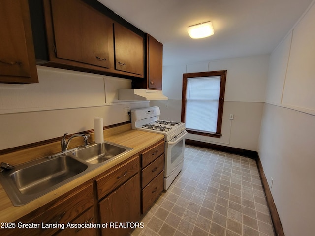 1201 Climax St, Lansing, MI 48912 - kitchen featuring white gas range, under cabinet range hood, and light countertops