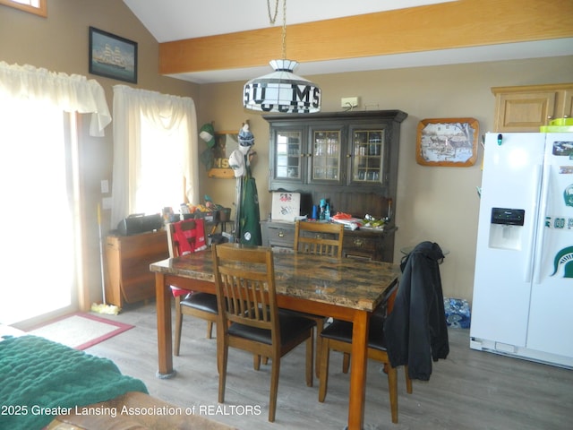 202 Broadway Rd, Houghton Lake, MI 48629 - dining area featuring light wood-style flooring and vaulted ceiling