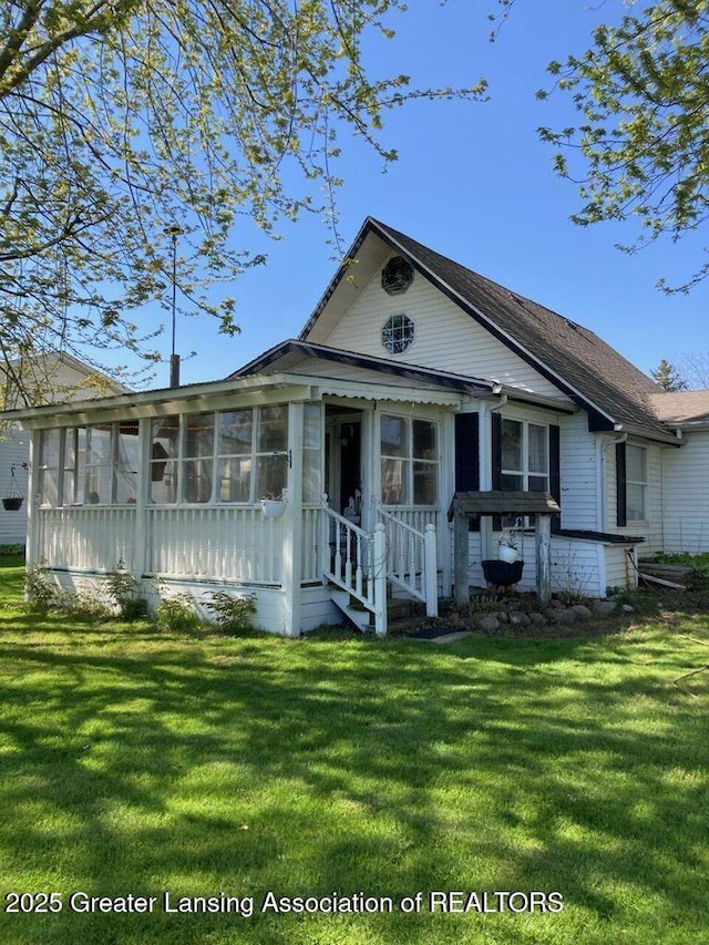 4701 W Channel Dr, Stanton, MI 48888 - view of front facade featuring a sunroom and a front yard