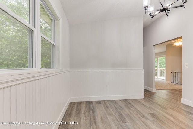 9481 S Clinton Trl, Eaton Rapids, MI 48827 - empty room with a chandelier, wood finished floors, and wainscoting