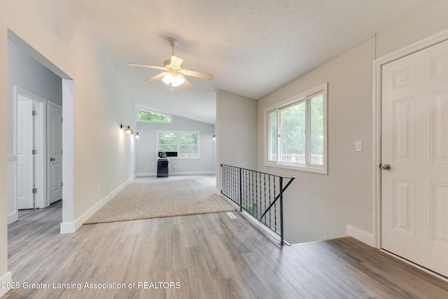 9481 S Clinton Trl, Eaton Rapids, MI 48827 - hallway featuring wood finished floors, an upstairs landing, and vaulted ceiling