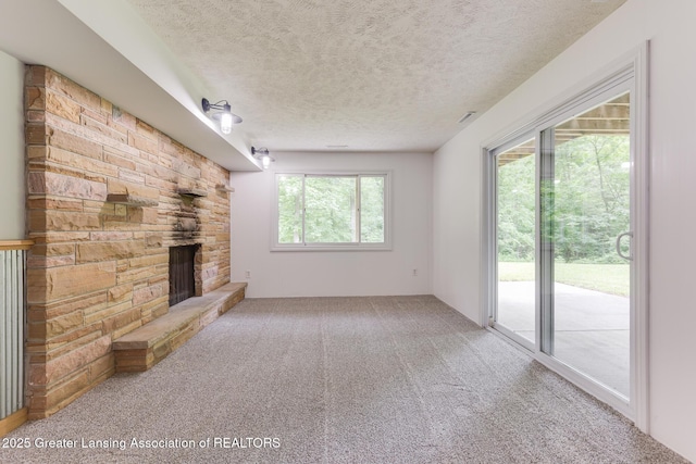 9481 S Clinton Trl, Eaton Rapids, MI 48827 - unfurnished living room with a textured ceiling, carpet, and a fireplace