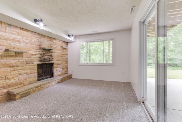 9481 S Clinton Trl, Eaton Rapids, MI 48827 - unfurnished living room featuring a stone fireplace, a textured ceiling, and carpet flooring