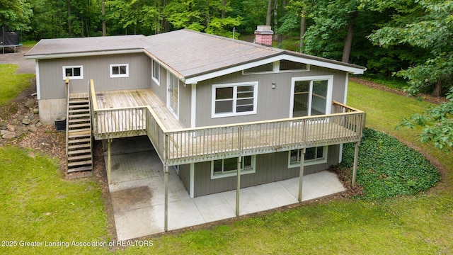 9481 S Clinton Trl, Eaton Rapids, MI 48827 - back of house featuring a patio, a chimney, a lawn, a wooden deck, and stairway