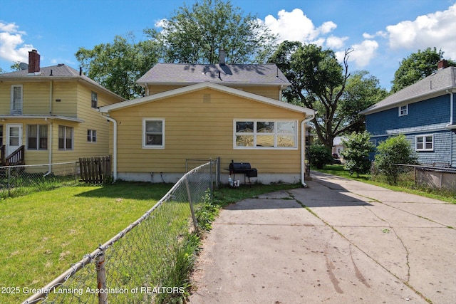 209 N Bowen St, Jackson, MI 49202 - rear view of property featuring a fenced backyard and concrete driveway