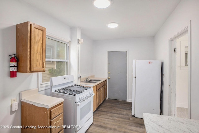 147 Isbell St, Lansing, MI 48910 - kitchen featuring white appliances, light countertops, wood finished floors, and brown cabinets