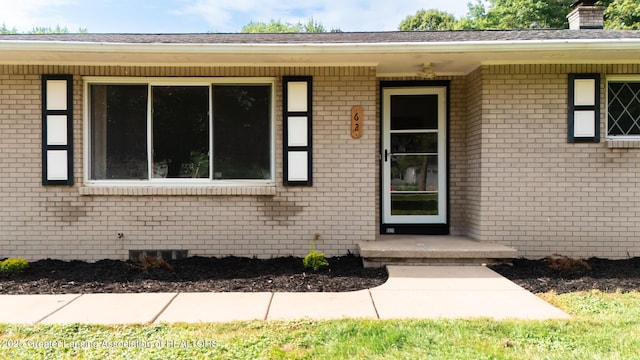 62 W Sherwood Rd, Okemos, MI 48864 - view of exterior entry featuring brick siding and a chimney