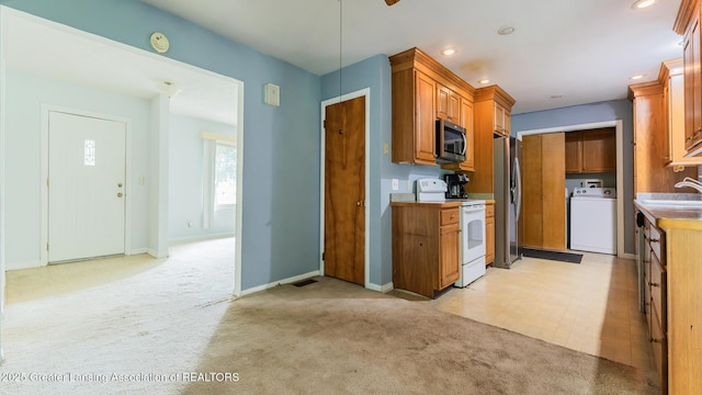 62 W Sherwood Rd, Okemos, MI 48864 - kitchen with stainless steel appliances, washer / clothes dryer, light carpet, brown cabinetry, and recessed lighting