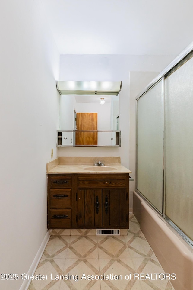62 W Sherwood Rd, Okemos, MI 48864 - bathroom with vanity, combined bath / shower with glass door, and inlaid floor details