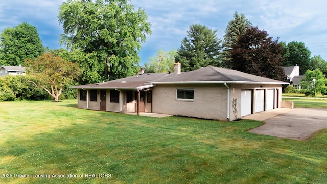 62 W Sherwood Rd, Okemos, MI 48864 - rear view of house featuring a chimney, a lawn, and brick siding