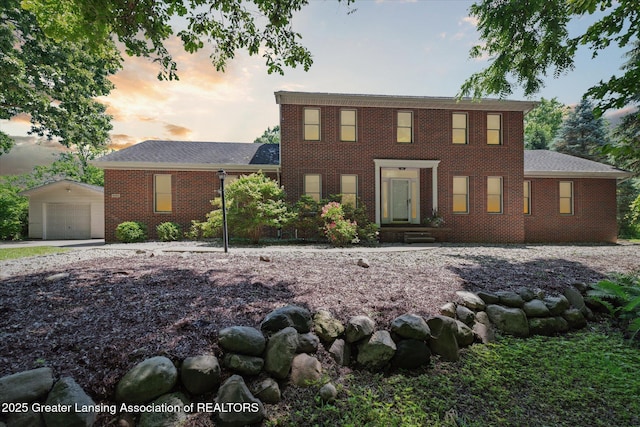 4084 Hulett Rd, Okemos, MI 48864 - colonial home featuring an outbuilding, brick siding, a detached garage, and driveway