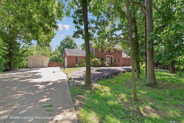 4084 Hulett Rd, Okemos, MI 48864 - colonial inspired home featuring driveway, a detached garage, an outdoor structure, and brick siding