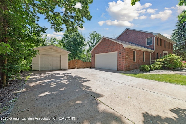 4084 Hulett Rd, Okemos, MI 48864 - view of side of property with brick siding, a gate, and a garage