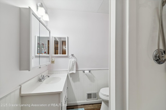 4084 Hulett Rd, Okemos, MI 48864 - bathroom with vanity, wainscoting, and wood finished floors