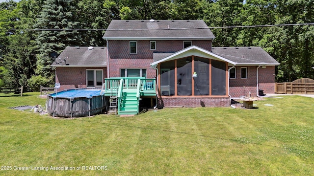 4084 Hulett Rd, Okemos, MI 48864 - back of house with a sunroom, brick siding, an outdoor pool, and a deck