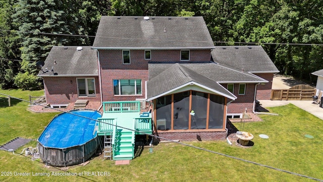 4084 Hulett Rd, Okemos, MI 48864 - rear view of house with a sunroom, brick siding, and a shingled roof