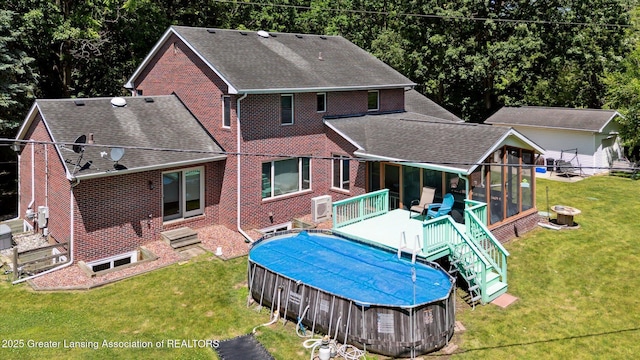 4084 Hulett Rd, Okemos, MI 48864 - rear view of property featuring a sunroom, roof with shingles, brick siding, a lawn, and an outdoor pool