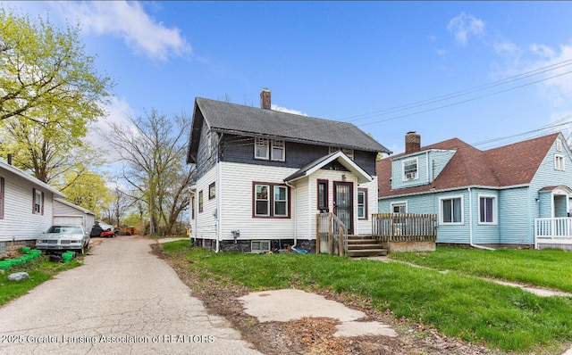 1017 W Oakland Ave, Lansing, MI 48915 - view of front of house featuring a chimney and a front yard