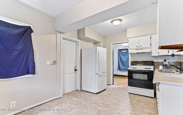 1017 W Oakland Ave, Lansing, MI 48915 - kitchen featuring freestanding refrigerator, range with electric stovetop, under cabinet range hood, light countertops, and white cabinetry