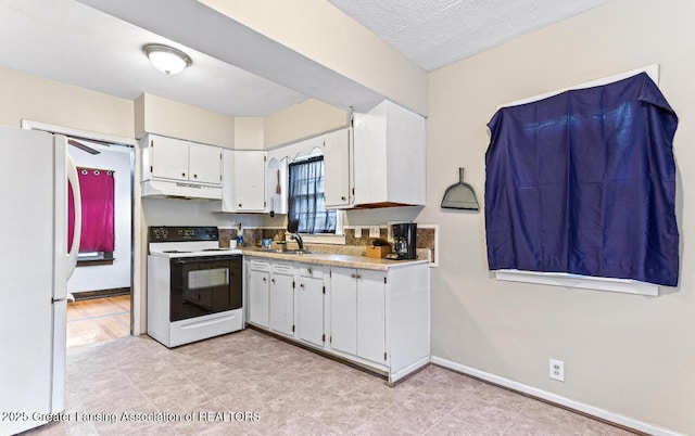 1017 W Oakland Ave, Lansing, MI 48915 - kitchen with electric stove, freestanding refrigerator, under cabinet range hood, and white cabinetry