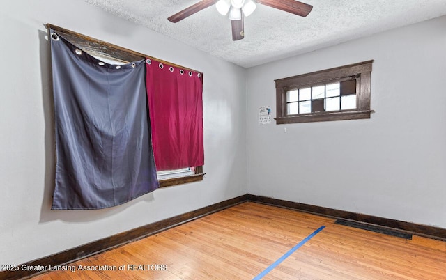 1017 W Oakland Ave, Lansing, MI 48915 - spare room with a textured ceiling, a ceiling fan, and wood finished floors