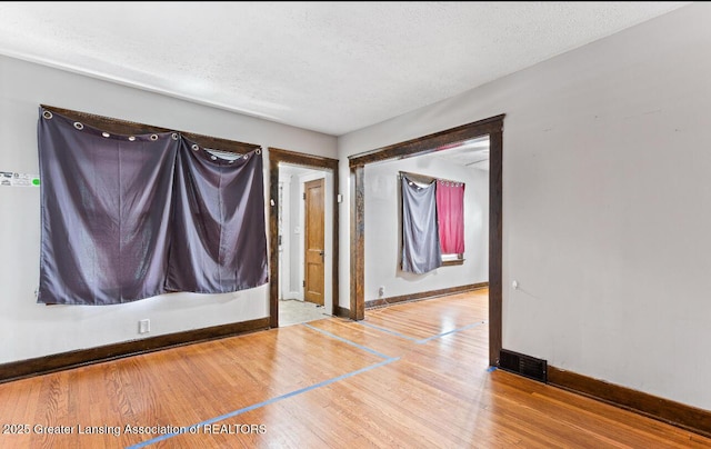 1017 W Oakland Ave, Lansing, MI 48915 - spare room with wood finished floors and a textured ceiling