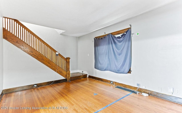 1017 W Oakland Ave, Lansing, MI 48915 - empty room with stairs and wood finished floors