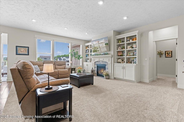 11167 Windswept Dr, Grand Ledge, MI 48837 - living room featuring a fireplace with flush hearth, a textured ceiling, carpet flooring, and recessed lighting