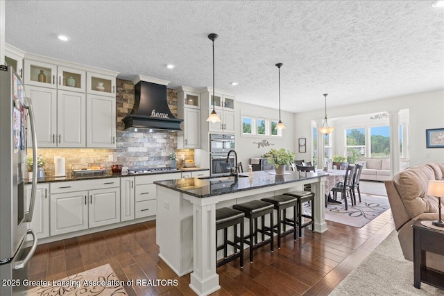11167 Windswept Dr, Grand Ledge, MI 48837 - kitchen featuring custom range hood, stainless steel appliances, open floor plan, dark wood-style floors, and plenty of natural light