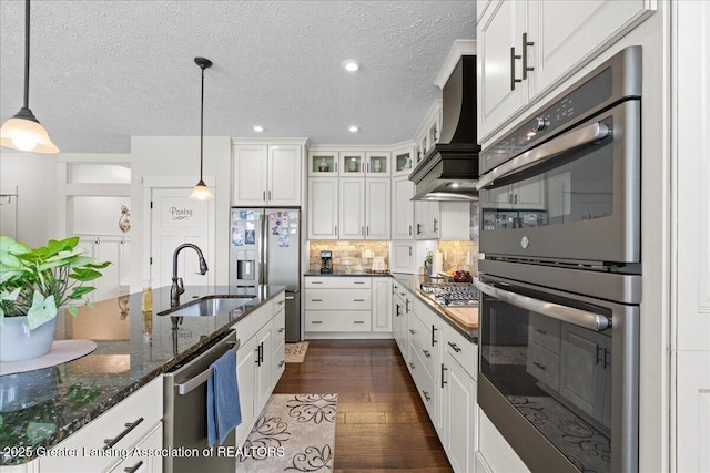 11167 Windswept Dr, Grand Ledge, MI 48837 - kitchen featuring stainless steel appliances, white cabinets, glass insert cabinets, decorative light fixtures, and a textured ceiling