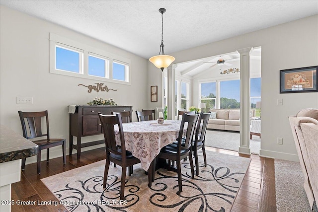 11167 Windswept Dr, Grand Ledge, MI 48837 - dining space with plenty of natural light, a ceiling fan, dark wood-style floors, lofted ceiling, and decorative columns