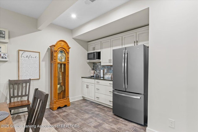 11167 Windswept Dr, Grand Ledge, MI 48837 - kitchen featuring freestanding refrigerator, dark countertops, white cabinetry, beam ceiling, and dark wood-style floors