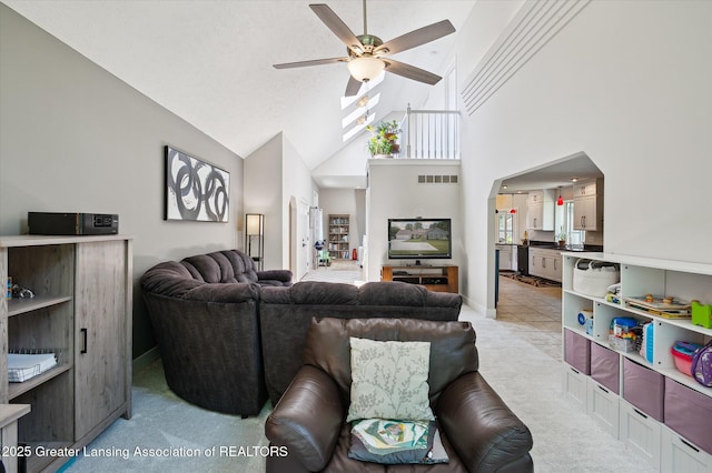 2605 College Rd, Holt, MI 48842 - living room with ceiling fan, light colored carpet, and high vaulted ceiling