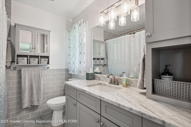 2605 College Rd, Holt, MI 48842 - bathroom featuring tile walls, vanity, and tile patterned flooring