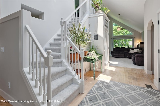 2605 College Rd, Holt, MI 48842 - staircase with high vaulted ceiling, a ceiling fan, and wood finished floors