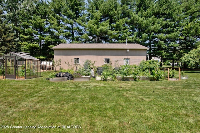 2605 College Rd, Holt, MI 48842 - view of property exterior with a garden, a greenhouse, an outdoor structure, and a yard