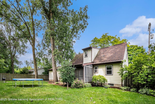 1614 N Eifert Rd, Holt, MI 48842 - rear view of property featuring a trampoline, a shingled roof, and a sunroom
